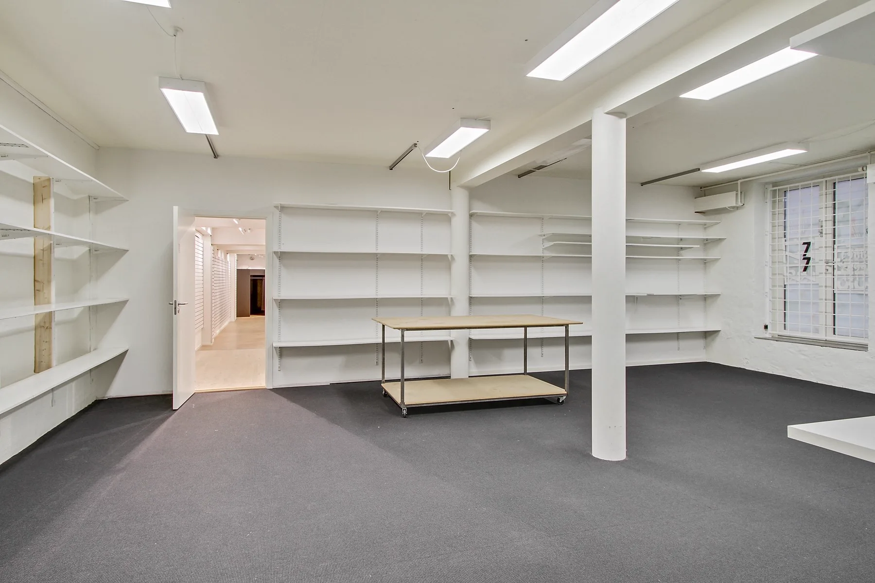 Tørt kælderlager med god loftshøjde under butikken